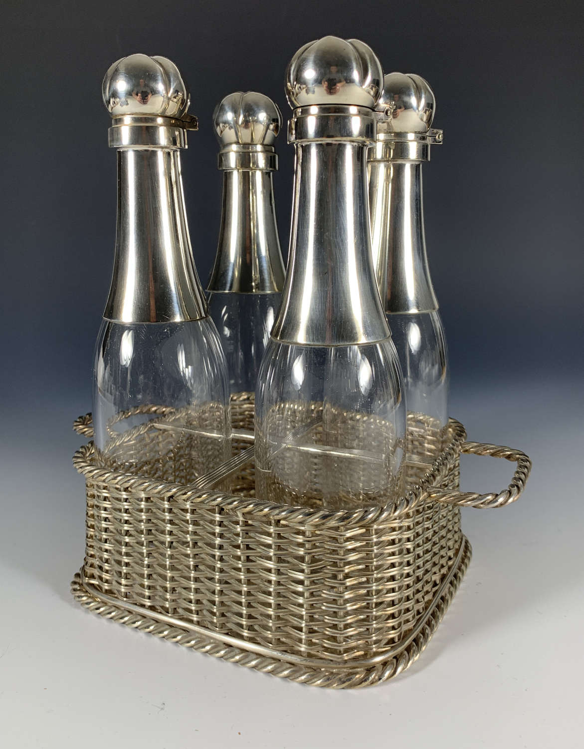A four piece Champagne decanter set in woven basket