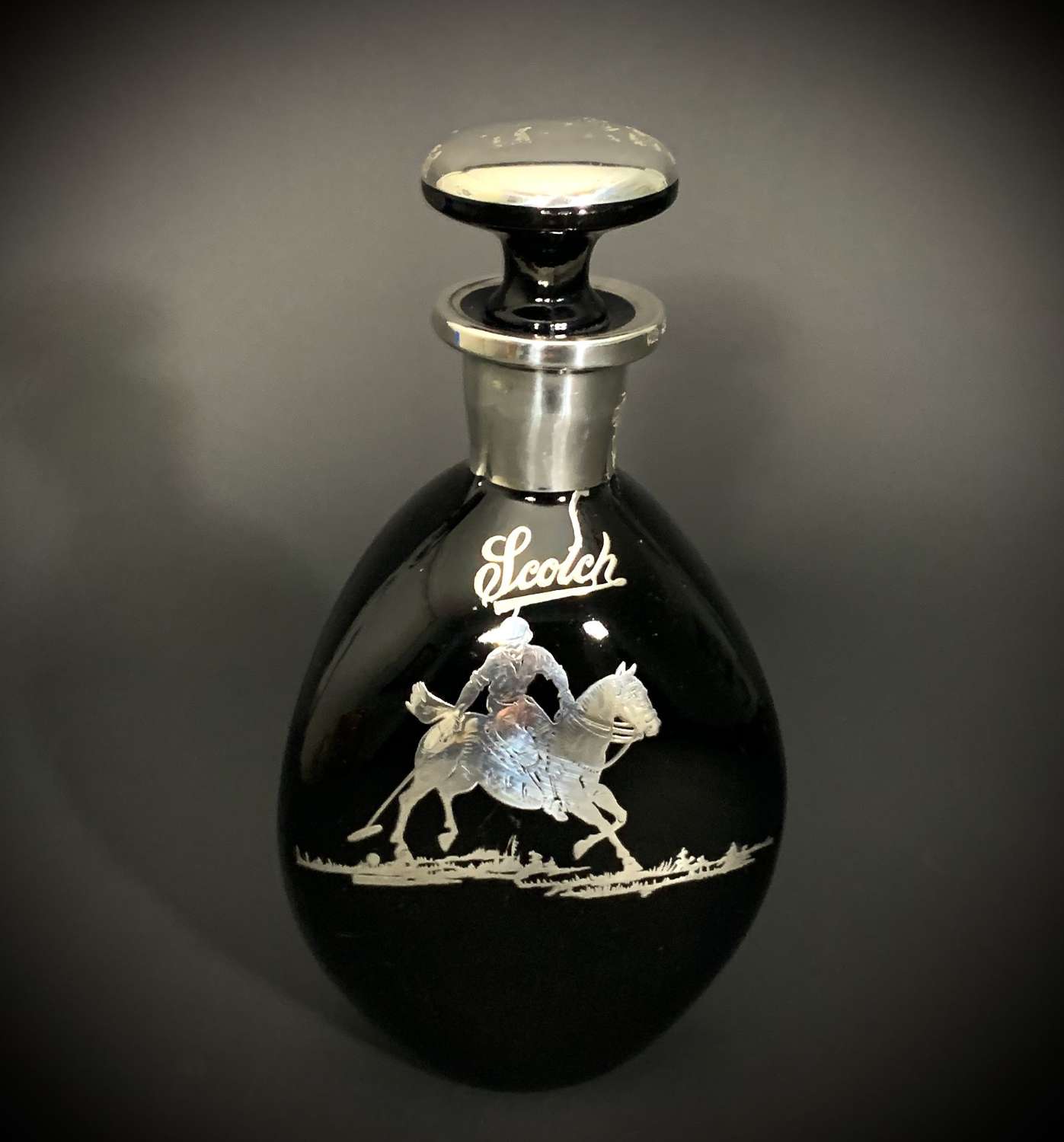 An obsidian glass & inlaid silver decanter depicting a Polo player