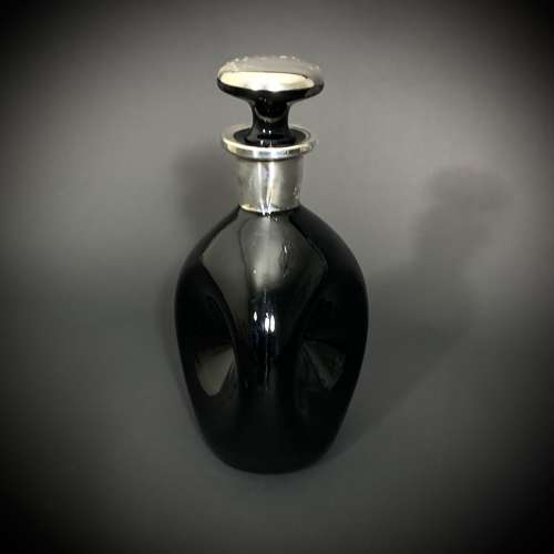 An obsidian glass & inlaid silver decanter depicting a Polo player