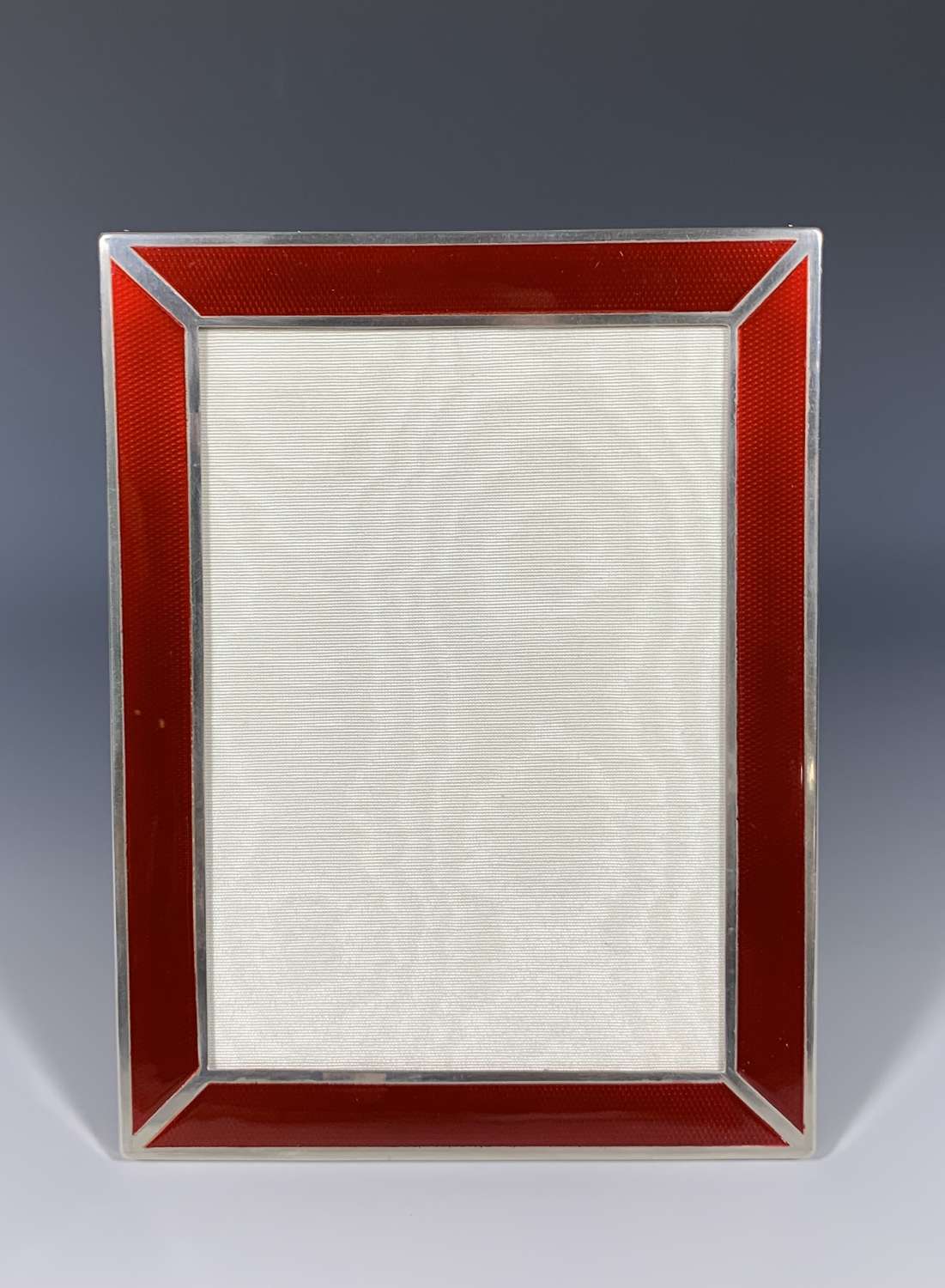 An Art Deco sterling silver and red guilloche enamel photograph frame