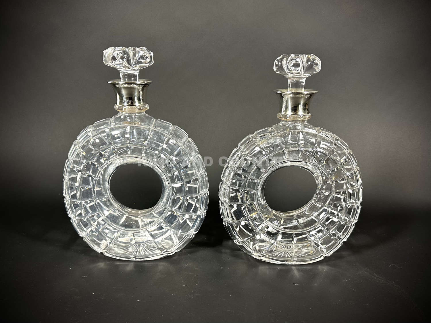 An Art Deco pair of Toroid / Car Wheel decanters by Mappin & Webb